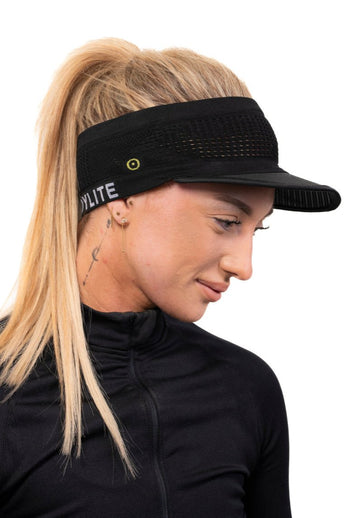 A woman wearing a black running visor with a spiderweb design. The visor has the word 'BODYLITE' written on it.