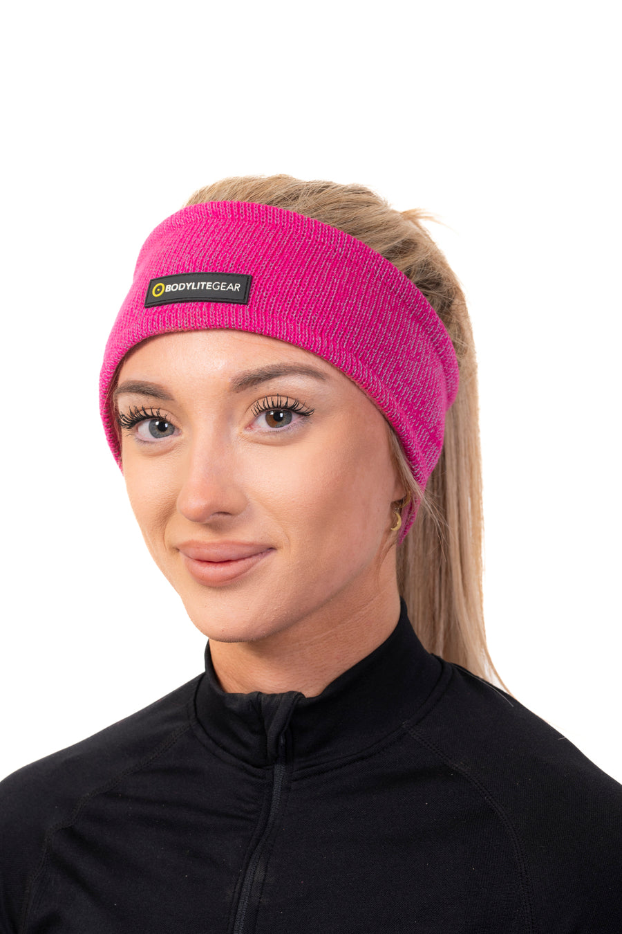 A woman wearing a reflective fleece lined headband in a pink colour