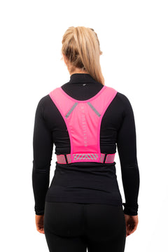 A person wearing a neon pink phone holder vest with reflective straps and detailing, designed for visibility during workouts.