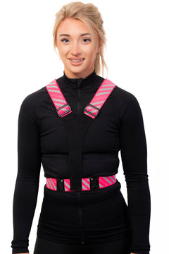 A person wearing a black vest with pink and black adjustable straps and a Velcro mounting pad.