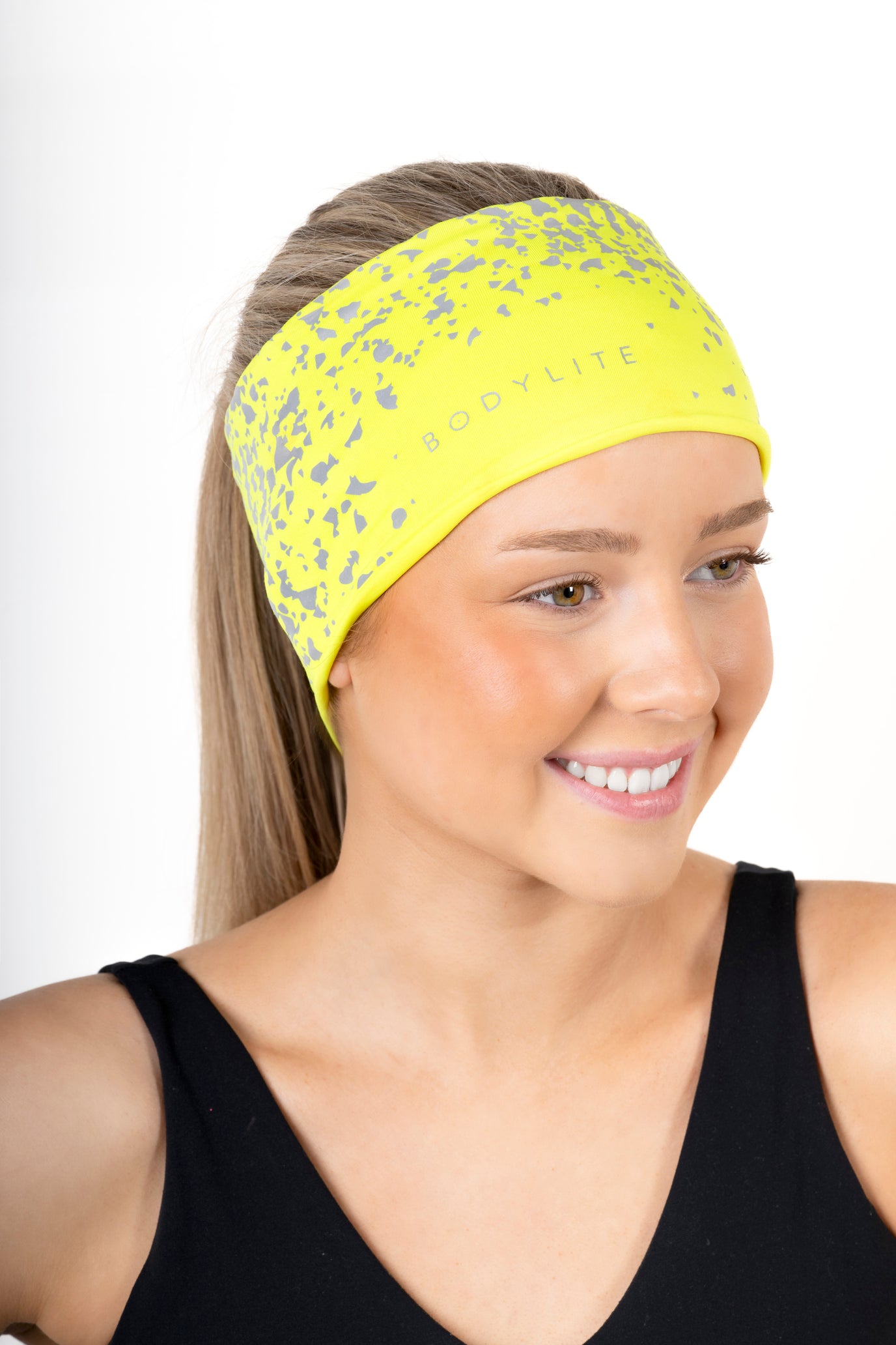 Woman wearing a yellow headband with a floral pattern on a white background